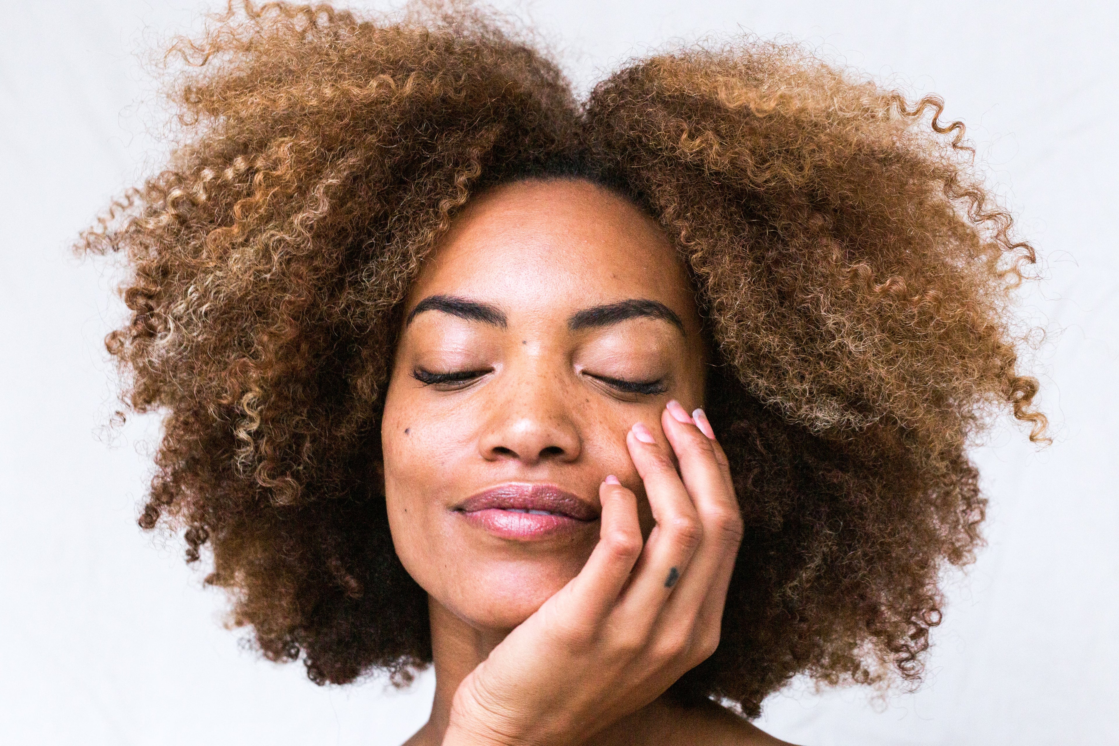 Photo of a woman holding her face representing youthful skin from consuming marine collagen